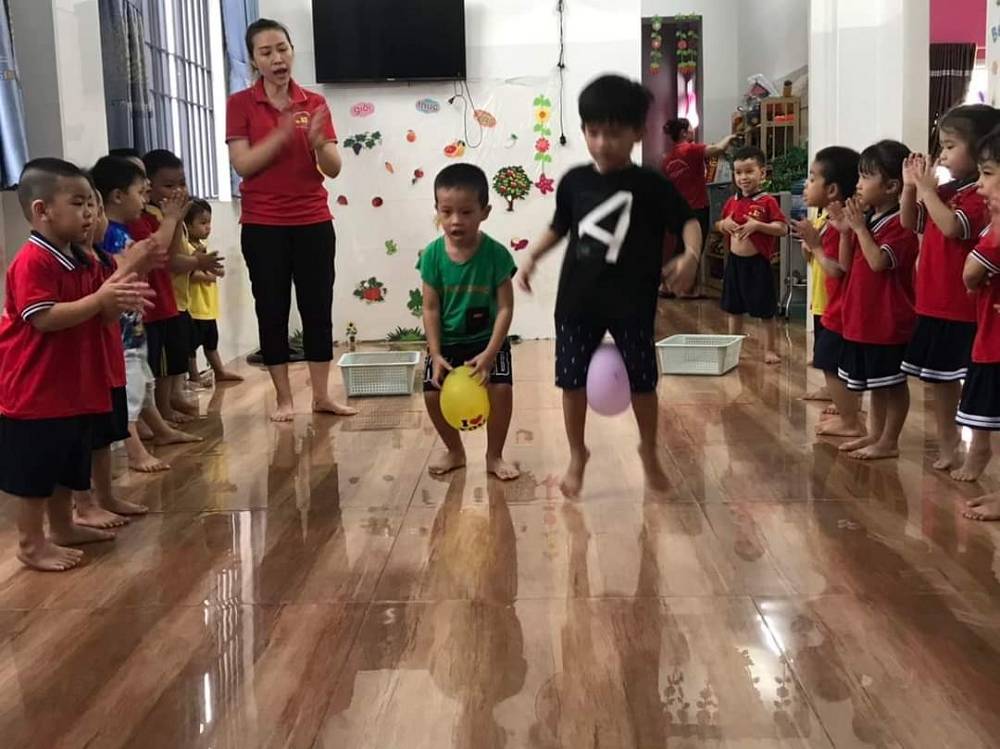 Trẻ tham gia trò chơi Kẹp bóng bằng chân