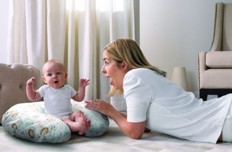 Hỗ trợ bé tập ngồi bằng gối mềm.