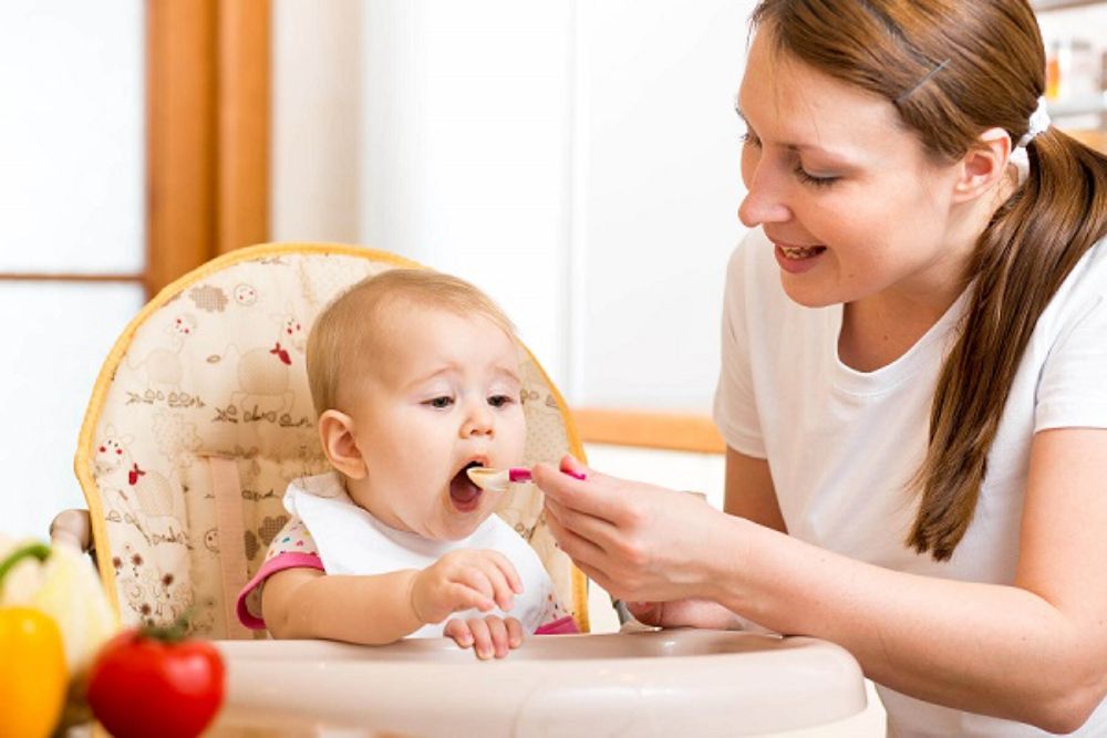 Bé ngồi vững và hứng thú với thức ăn là dấu hiệu sẵn sàng ăn cơm
